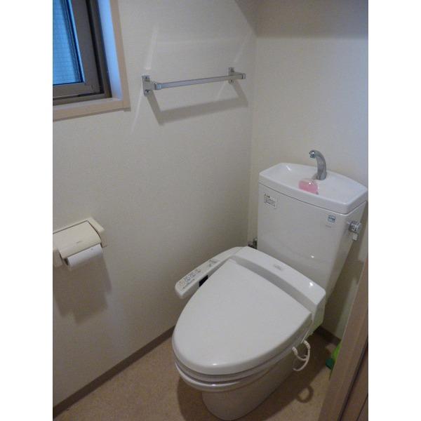 Toilet. There is a window and housed in a toilet