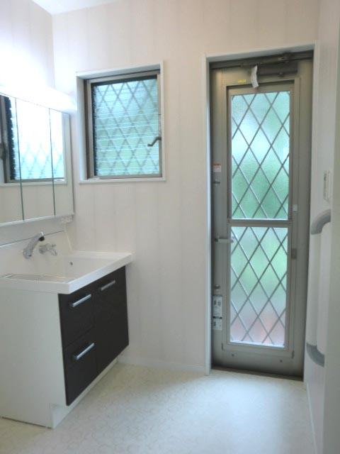 Wash basin, toilet. Flow line there is a back door is also good in the washroom. Wash basin is three-sided mirror type. The back of the mirror is housed