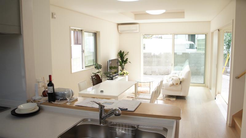 Model house photo. Happily dishes while chatting with children in the face-to-face kitchen