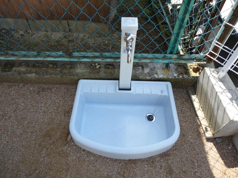 Other. It is outside washing with water in the garden.