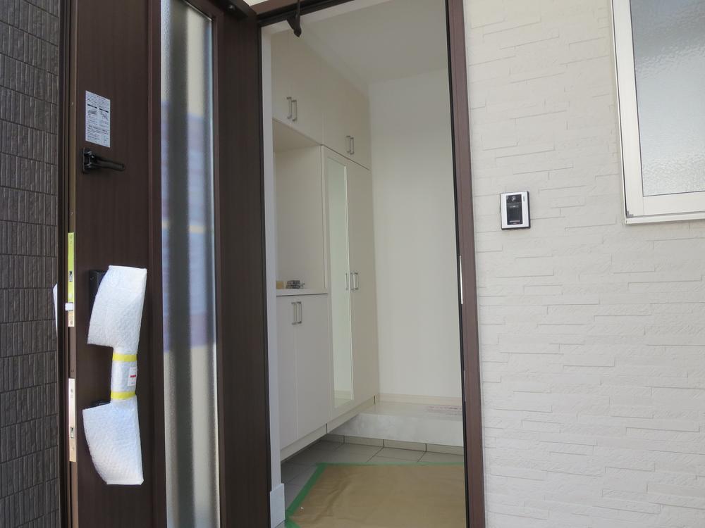 Entrance. It is a door there between heavy of dark brown. 