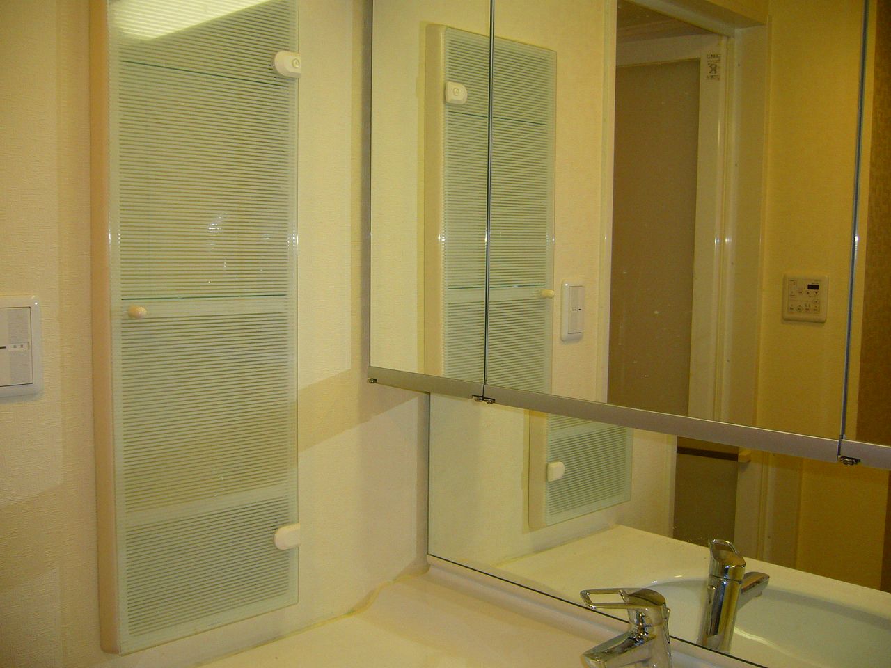 Washroom. Of the three-sided mirror is a wash basin