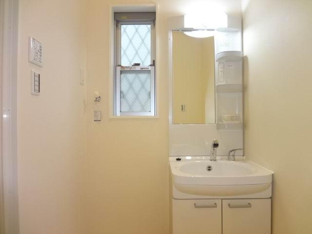Wash basin, toilet. First floor powder room. Shampoo dresser with a three-way mirror cabinet.