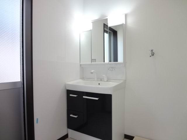 Wash basin, toilet. First floor powder room. Shampoo dresser with a three-way mirror cabinet.