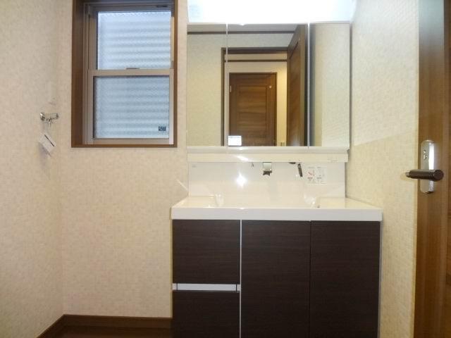 Wash basin, toilet. First floor powder room. Shampoo dresser with a three-way mirror cabinet.