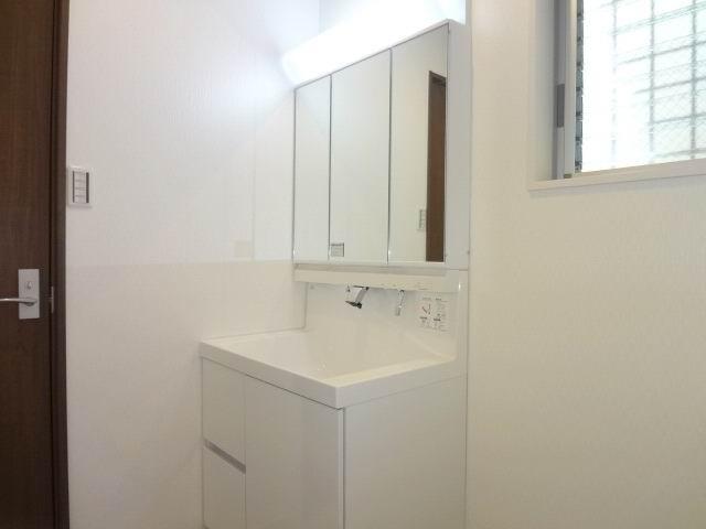 Wash basin, toilet. First floor powder room. Shampoo dresser with a three-way mirror cabinet.