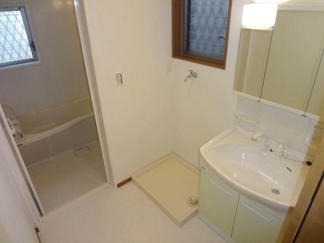 Wash basin, toilet. First floor powder room. Three sides is a mirror shampoo with a dresser with cabinet.
