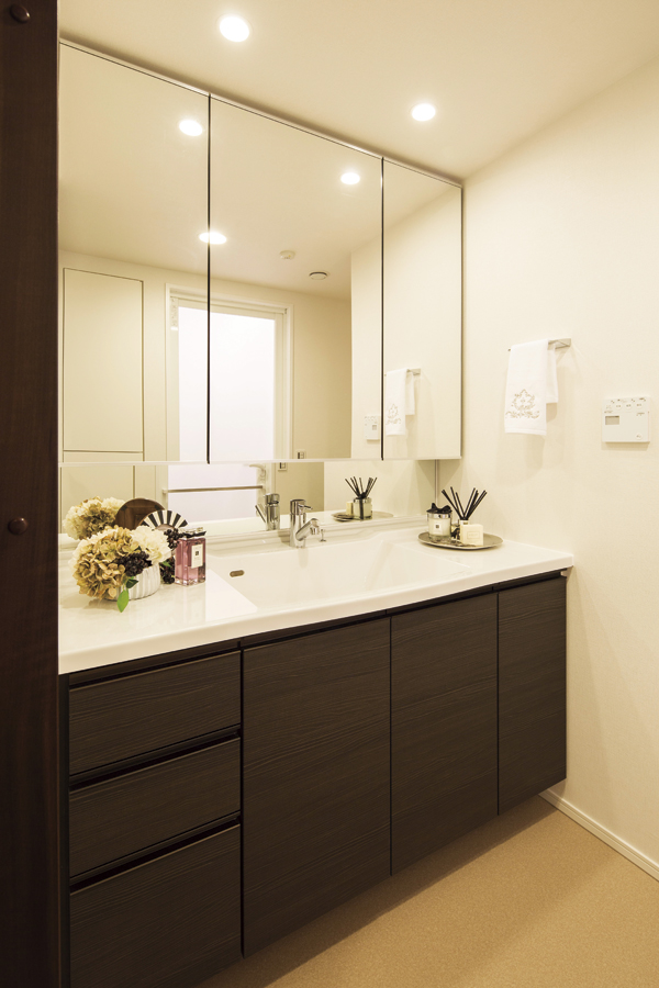 Bathing-wash room.  [Dressing room] Vanity, which features a capacity rich three-sided mirror back storage. Full of cleanliness, Adopt a stylish artificial marble basin bowl integrated counter. Cabinet of the surface material is stuck to the magnificent texture and color. Convenient scales storage space at the bottom have also been secured (D type model room)