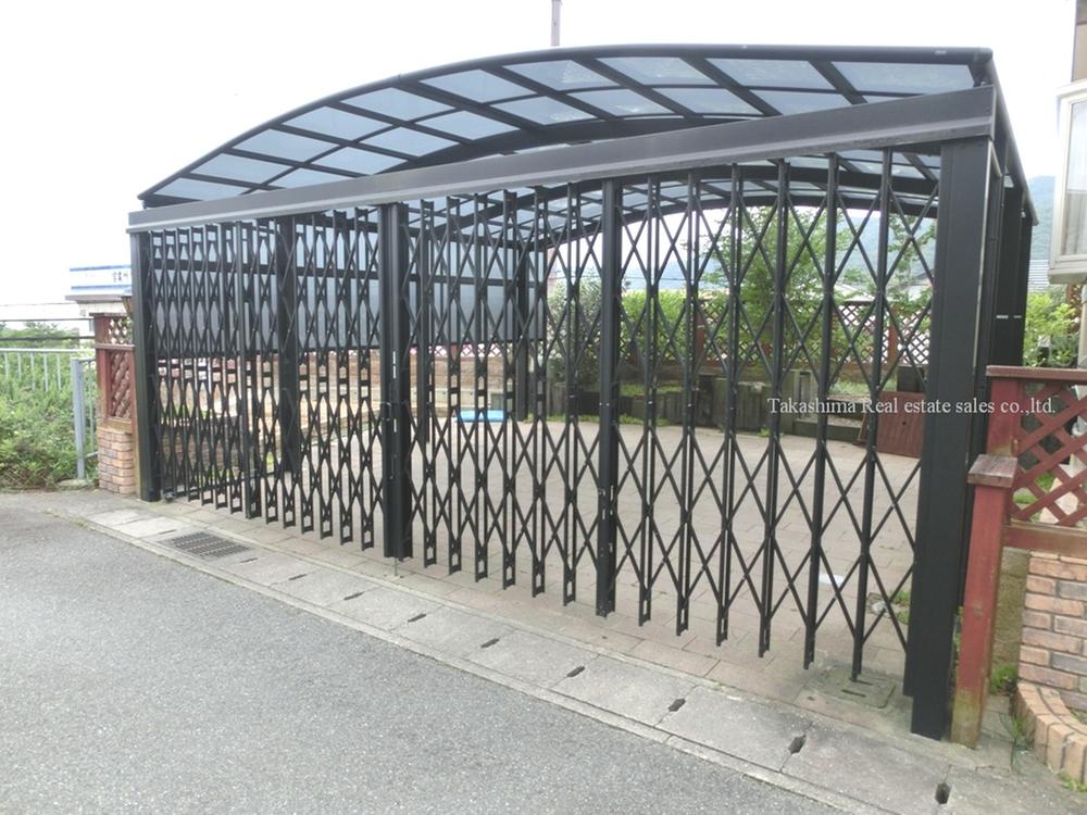 Parking lot. You can park two in parallel. Roofed.