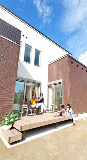 Wood deck facing the wide garden, Open living under the blue sky. Outdoor mood likely to enjoy a tea time and barbecue (model house)