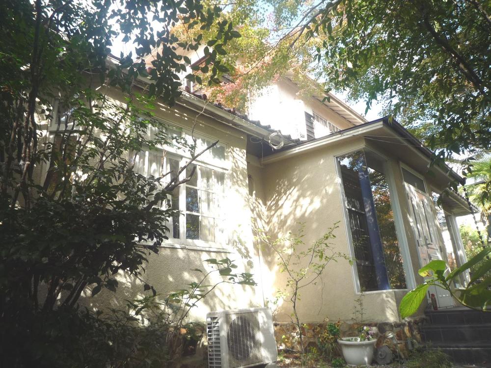 Local appearance photo. It is surrounded by a garden of trees.