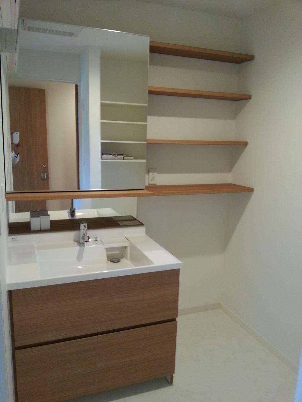 Wash basin, toilet. It is very wide washroom.