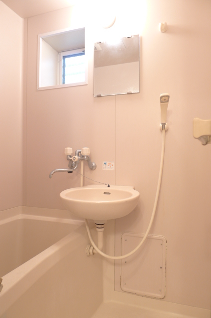 Bath. With a window there is a wash basin in the bath