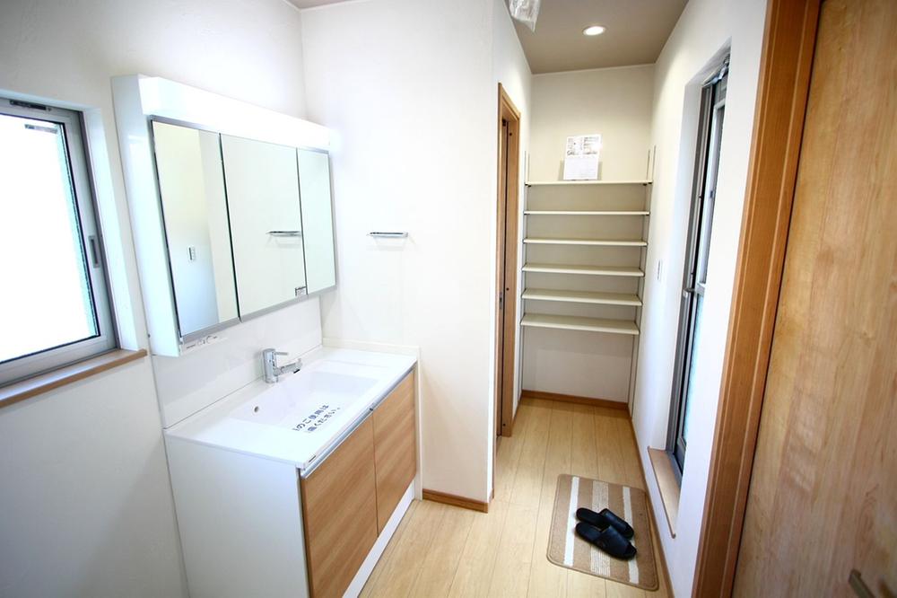 Wash basin, toilet. There is a wealth of storage space in the washroom.