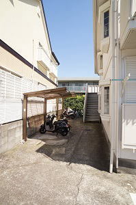 Building appearance. There is a parking lot with a roof