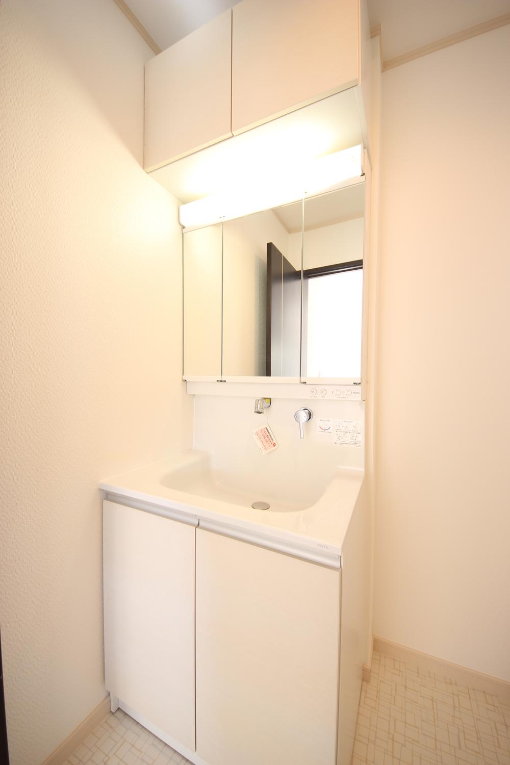 Wash basin, toilet. Vanity of three-sided mirror. Toothbrush and hair dressing on the back side can be opened and closed with three planes, It can be stored, such as dryer.