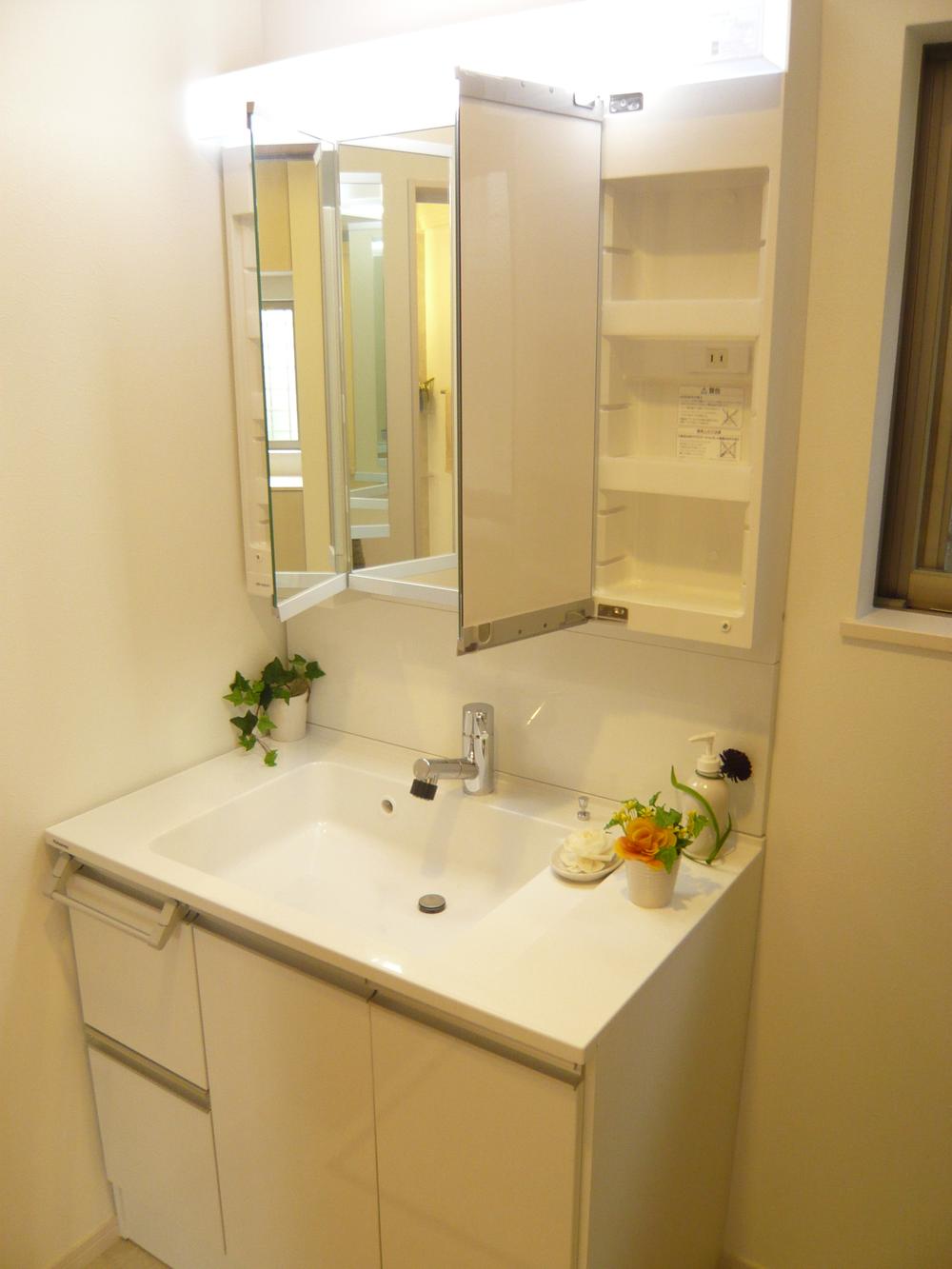 Wash basin, toilet. There is storage space in the back of the three-sided mirror. 