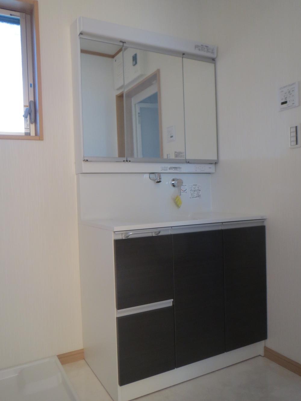 Wash basin, toilet. There is storage space in the back of the three-sided mirror