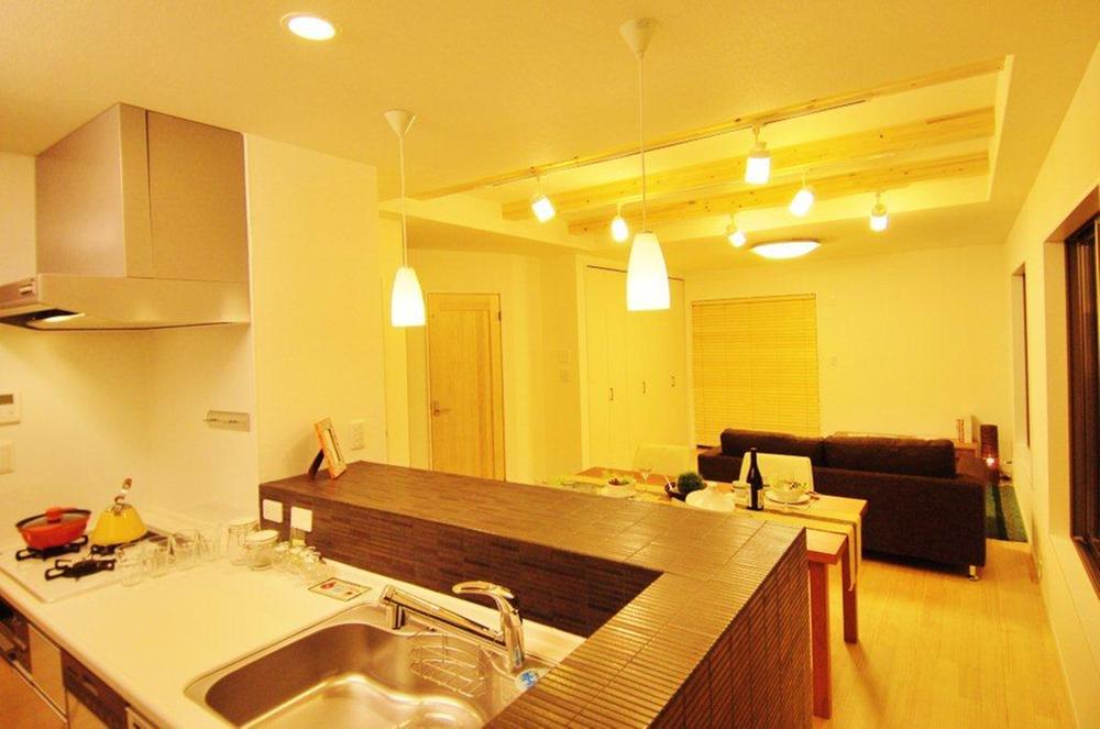 Kitchen. Living and dining and kitchen with a sense of unity is you can feel To spacious the LDK. Kitchen tile counter is popular with the hand may be functionality hide. (Model house)