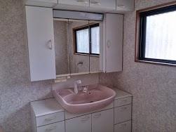 Wash basin, toilet. Shampoo dresser is attached. Determined pat large mirror.