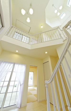 Wood deck is continuous in the entrance hall the other side of the airy atrium