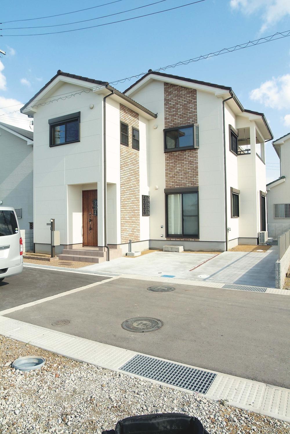 Entrance door to No. 15 area model house white outer wall of design is there to put a tile to a part of the attractive outer wall, It has become the accent.. No. 15 land model house