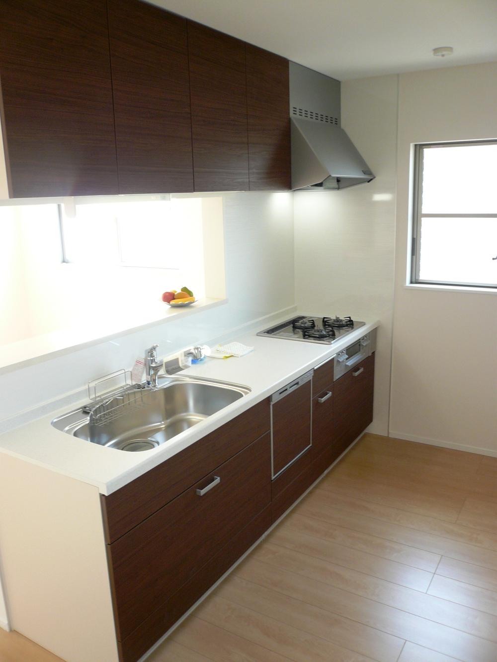 Kitchen. Because the stylish kitchen counter kitchen with calm woodgrain, You can dish fun while conversing with family. Equipped with dishwasher is standard. (Local photo)