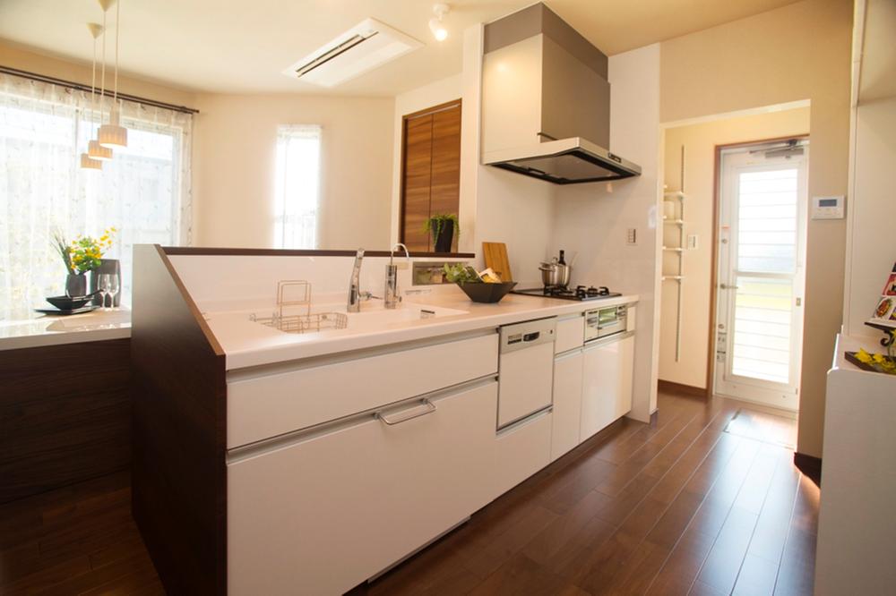 Model house photo.  [Model house kitchen] Impressive face-to-face system Kitchen. Facilities enhancement, such as dish washing dryer. Since overlooking the living, It is housework while watching the figure of children.