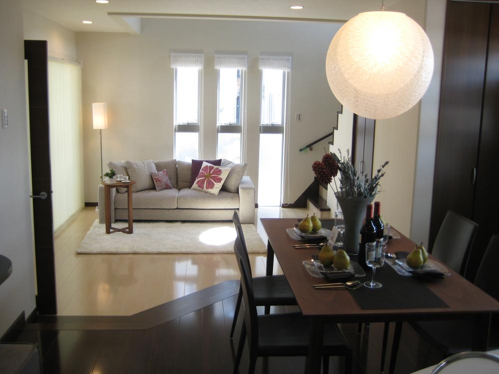 Model house photo.  [Model house living] Open living. All living room overlooking from the kitchen. Come by inserting the light of Sansan and the sun is from the longitudinal slit window of the front.