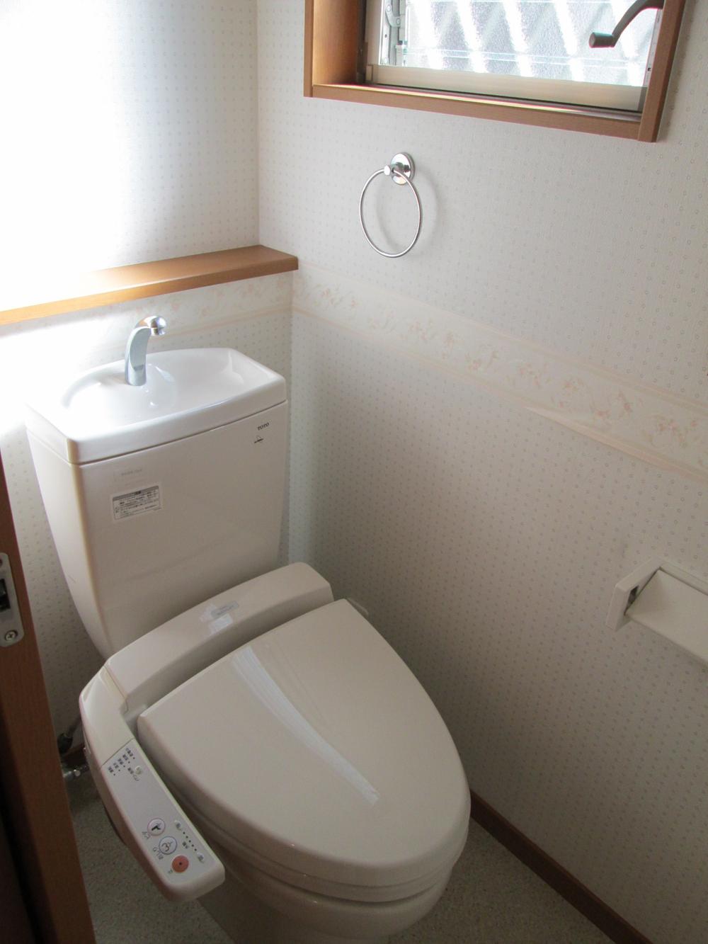 Toilet. It is a window with bright restroom. 