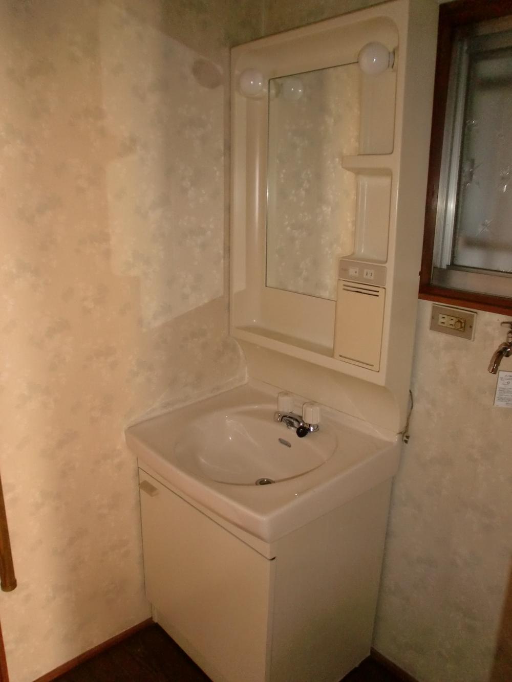 Wash basin, toilet. It is a washroom with a clean.