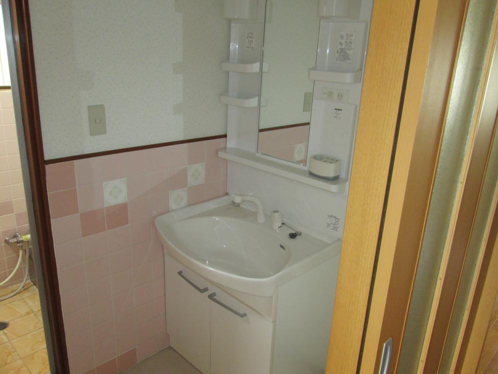 Wash basin, toilet. It is a washroom with a clean. 