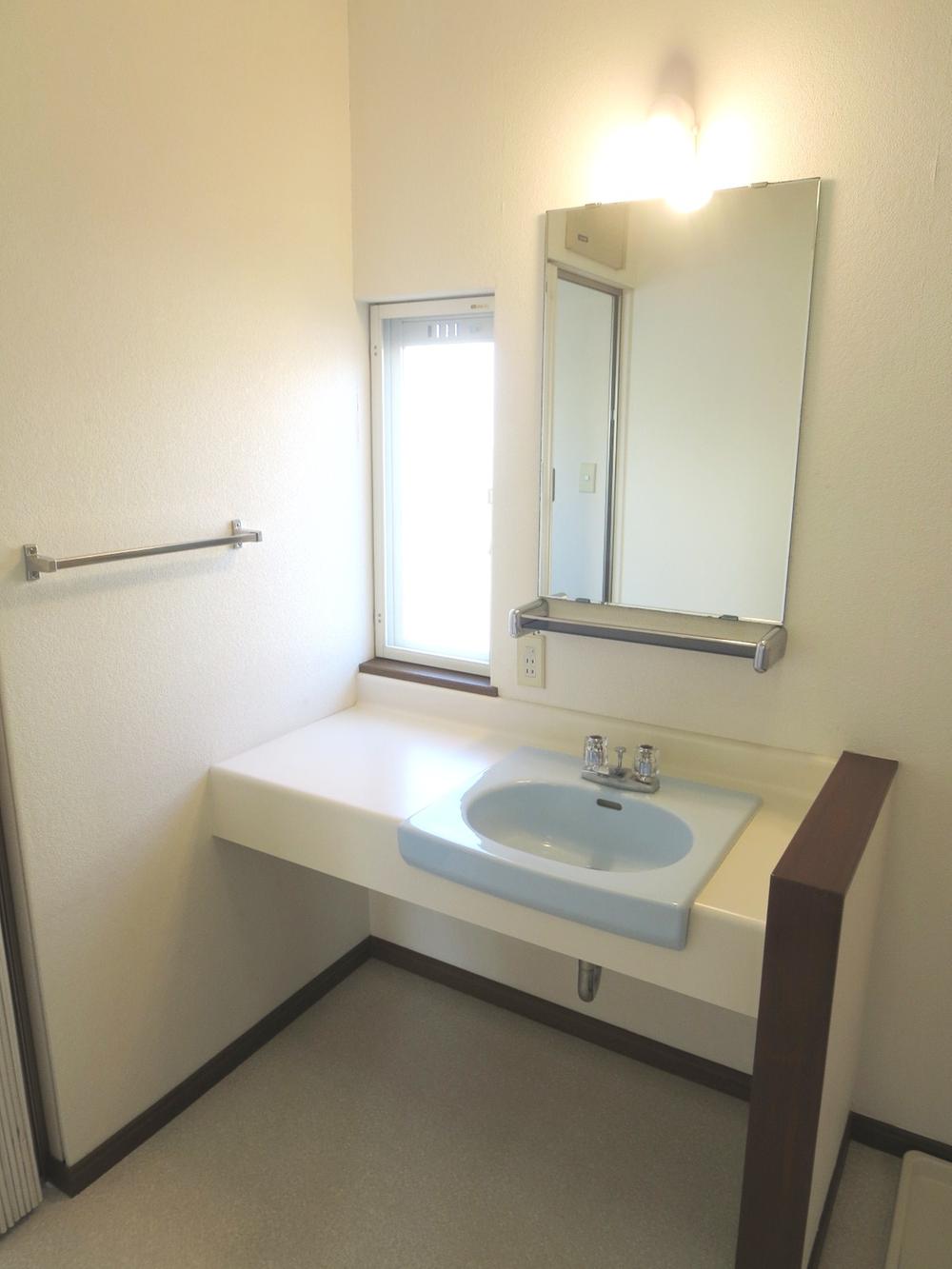 Wash basin, toilet. Washroom is also bright plug yang from window