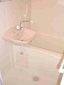 Bath. It is pure white bath equipped with a wash basin.