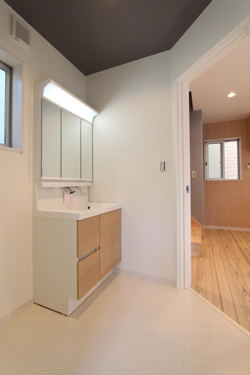 Wash basin, toilet. Three-sided mirror is standard equipment in a wide washroom.