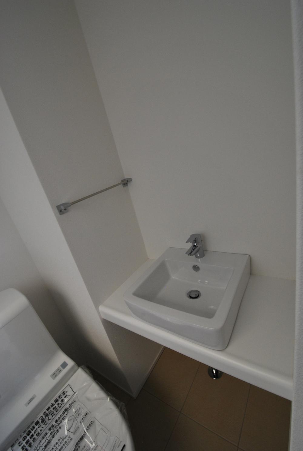 Toilet. Stylish tile floor toilet. Also equipped with hand-washing facilities.