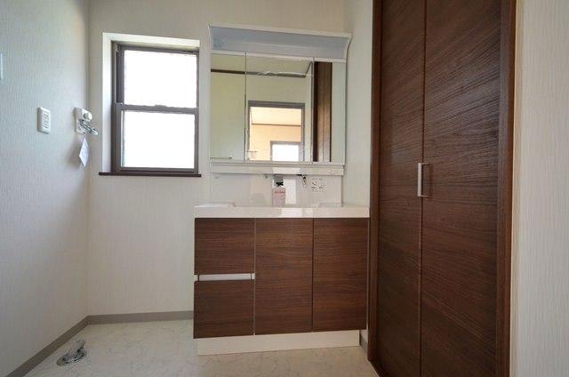 Wash basin, toilet. Three-sided mirror is vanity with shampoo dresser. There is also under-floor storage. (4 Building)