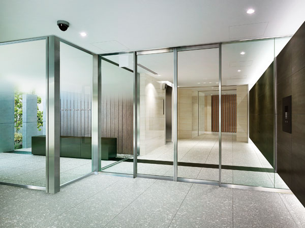 Features of the building.  [Entrance Hall & Exterior Terrace] From the entrance approach toward the entrance hall, The walls and floor were unified in a large design tile, Produce a sense of unity inside and outside. Switch on and off smoothly, It has achieved a space that snuggle up to the heart. Also, Indirect lighting that follows the inside through the glass wall of the auto door is, Together to produce a depth, Gently escort to the elevator a person who live. further, Wood louvers nestled on the walls of the exterior terrace and entrance hall, We caught the soft line of sight. (Rendering)