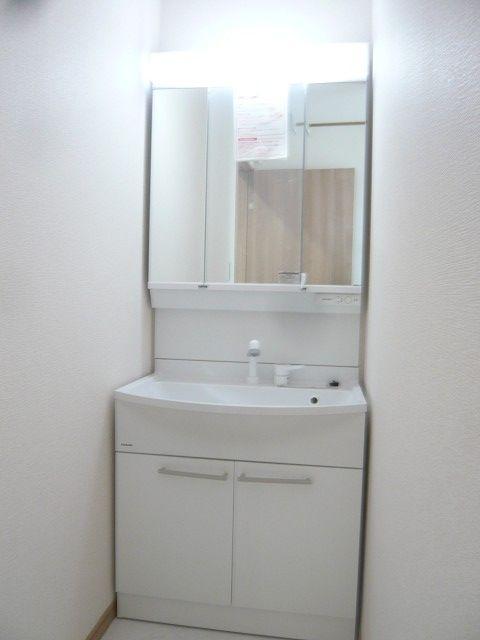 Wash basin, toilet. Vanity with a white clean. The back of the mirror has become a storage space.