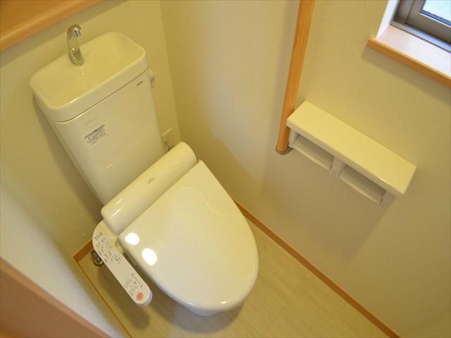 Toilet. Toilet with a handrail