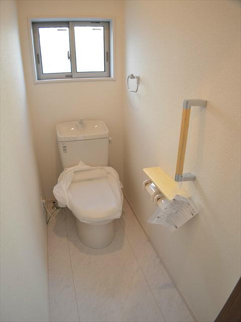 Toilet. Toilet with a handrail