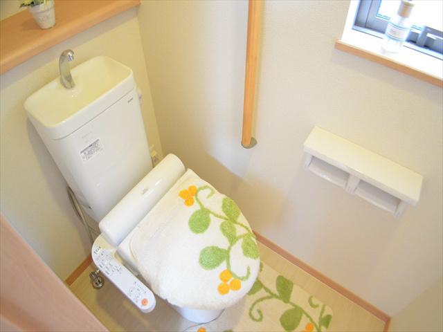 Toilet. Toilet with a handrail