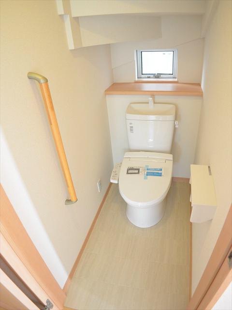 Toilet. Toilet with a handrail