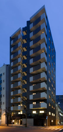 Buildings and facilities. Carved deep facade that emphasizes the vertical and horizontal line. Foundation of the building is a paste Motoishi of black granite, And nestled in the vertical lattice to the door of the wood tone bored a round window, Dignified has produced a magnificent certain stance.