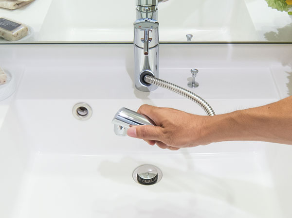 Bathing-wash room.  [Hand hose faucet] It has adopted a convenient hand hose faucets in such cleaning or vase of water put in the bowl.