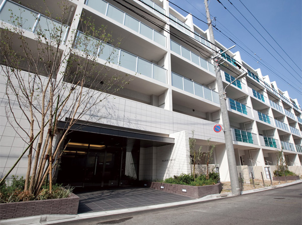 Shared facilities.  [appearance] Facade facing the front road, Transparency and lighting in the perforated block ・ Nestled feel the draft. Consideration to human scale in the garden lamp soft light leaks. Place a dedicated parking on the first floor dwelling unit.  ※ Except for some residential units (August 2013 shooting)