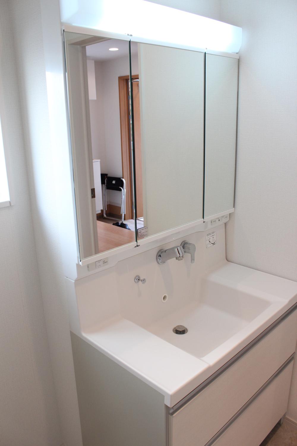 Wash basin, toilet. Three-sided mirror