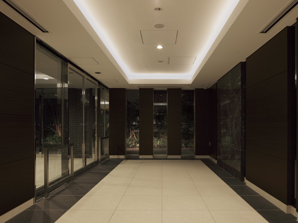 Features of the building.  [Entrance hall] Magnificent spread to the back of the high hotel-like entrance, Open space with a ceiling Trey. Such as the decoration of natural stone tiles and wood enhances the calm atmosphere, With to produce a space of Yingbin, We have to create a large window surface bright and open space. (2012.8 shooting)