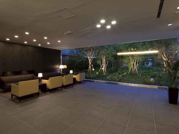 Shared facilities.  [Entrance Hall to greet gently views of the four seasons, which spread to one side] Against the background of the green of the evergreen, Entrance Hall of deciduous tree of red and yellow paint a vivid contrast. By combining in an atmosphere of calm on the floor and walls, It invites the line of sight to the view through the glass. Lounge-style sofa that was placed in the back is, Amid quiet music flows, Also available on such as meet up with chat and customers among residents. (2012.6 shooting)