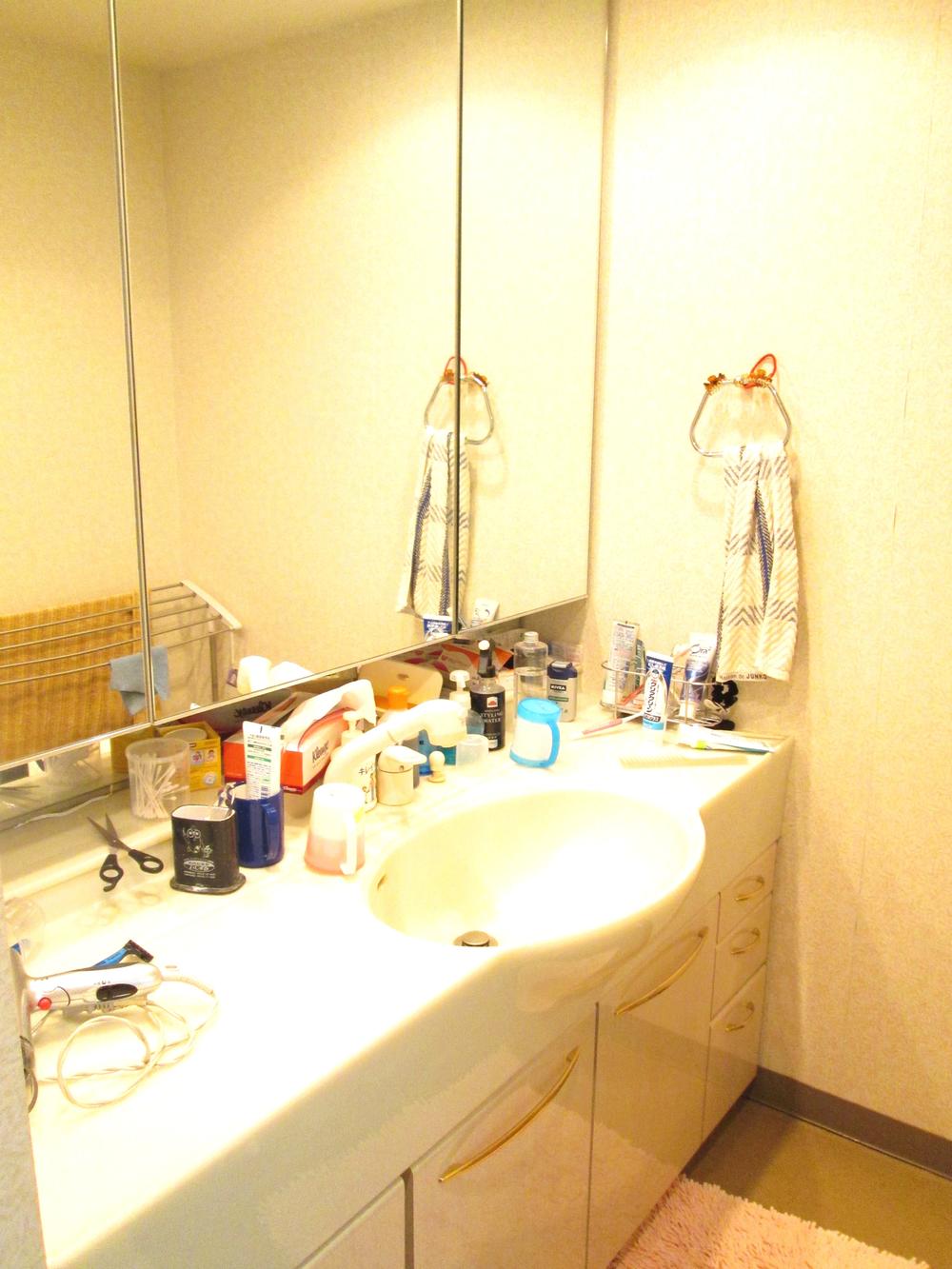 Wash basin, toilet. Three-sided mirror with vanity